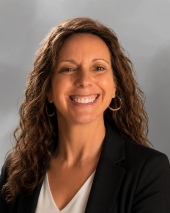 Woman with black blazer and long hair smiling